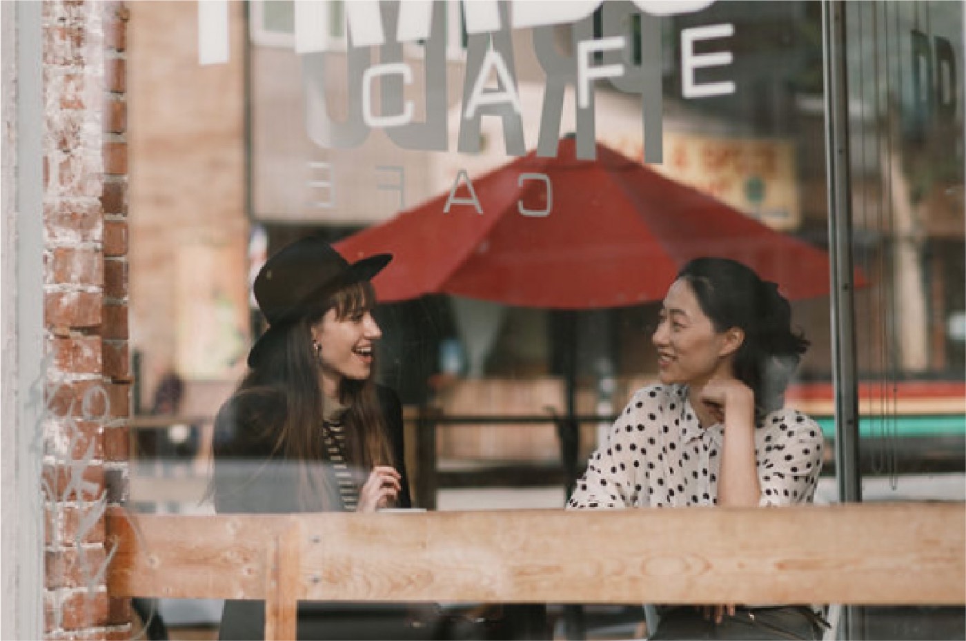 Friends at a caf&eacute; window on Commercial Drive